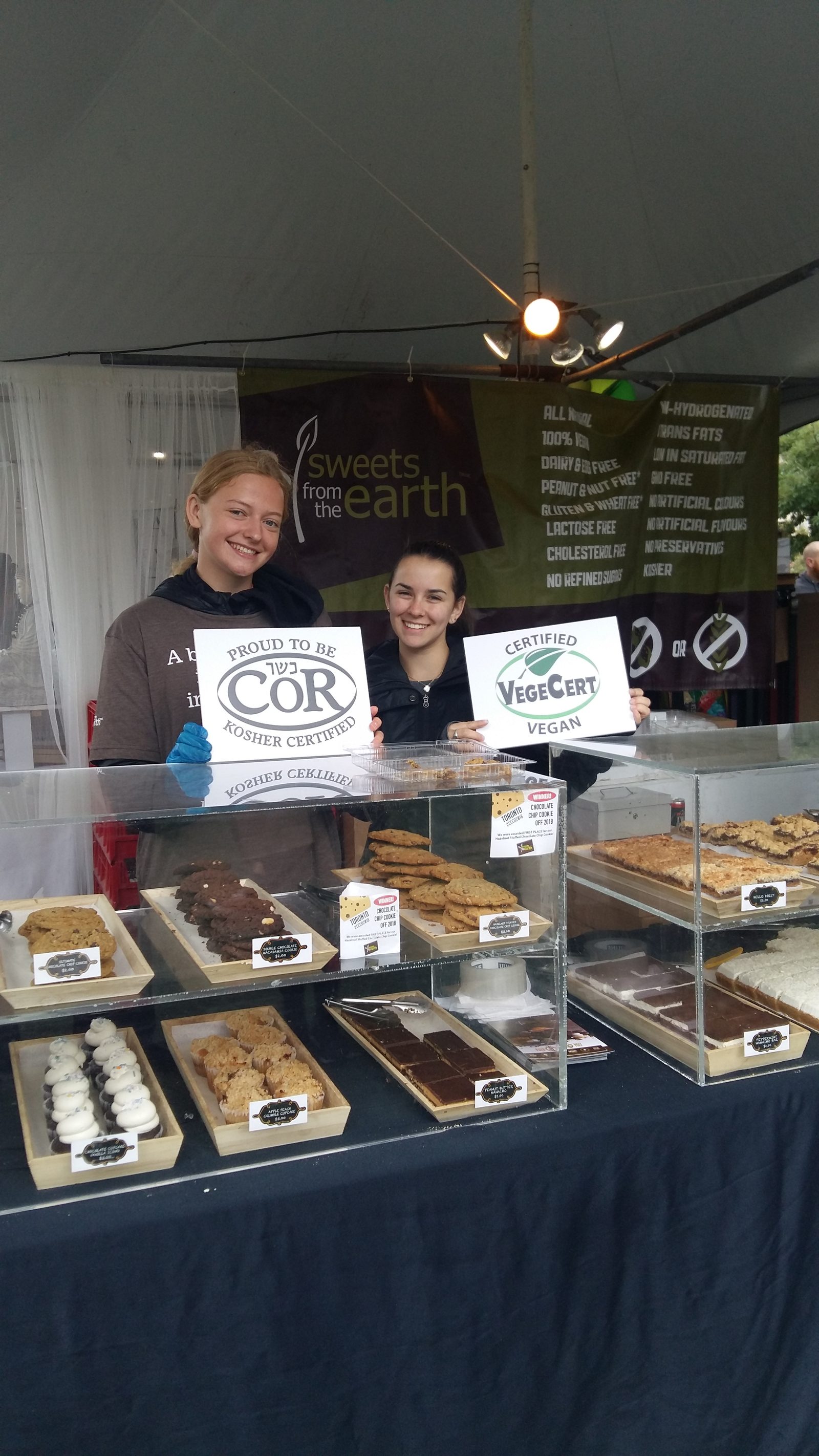 VegeCert team members at a trade show displaying Certified Vegan signage